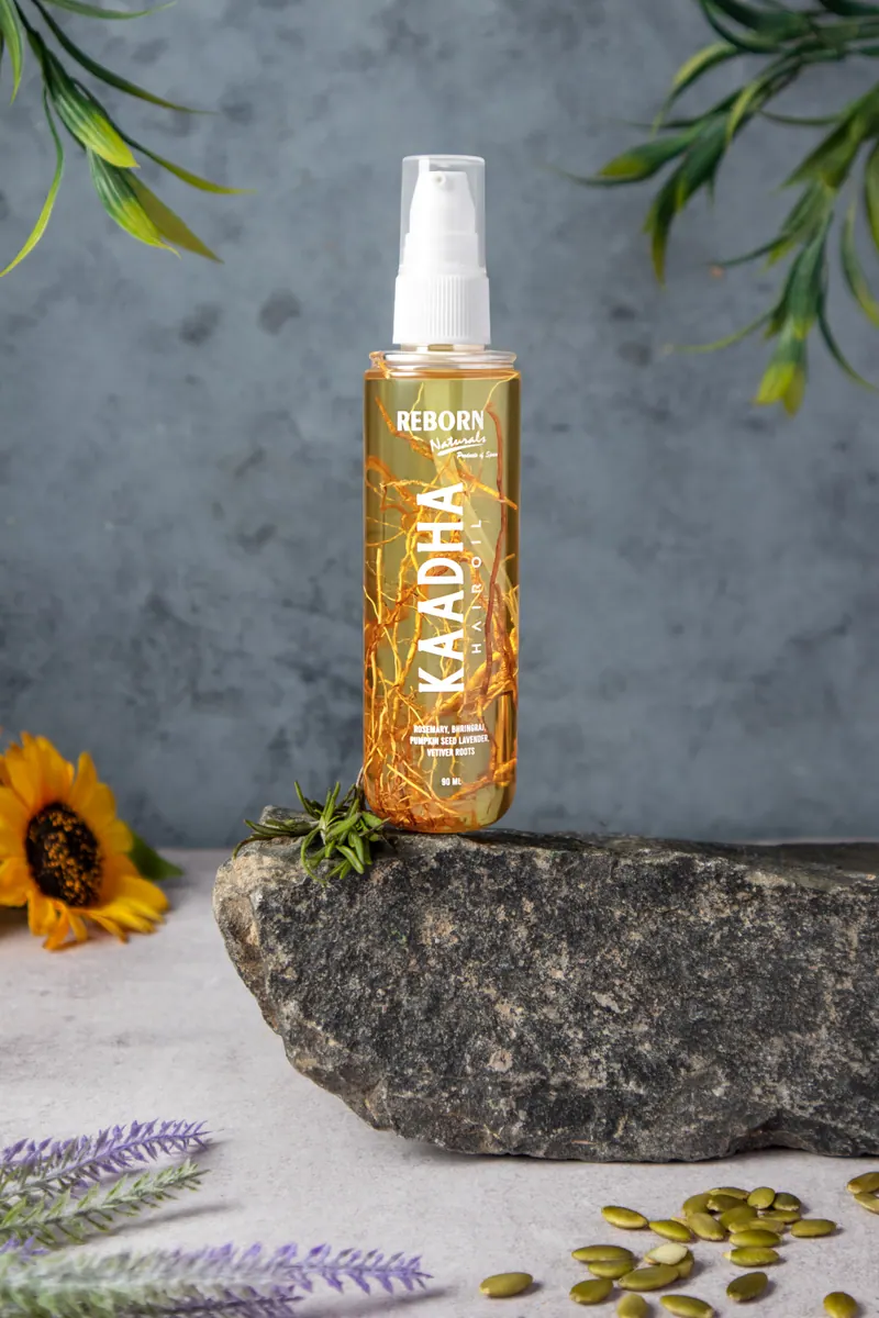 Kaadha Hair Oil on a stone with sunflower
